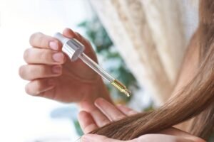 Application d'huile de ricin sur les cheveux avec une pipette